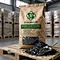 X-HUMATE Humic Acid Flakes, pure leonardite source, high-quality soil conditioner, 25kg kraft paper bag packaging on a wooden pallet, professional agricultural product photography with flake texture.